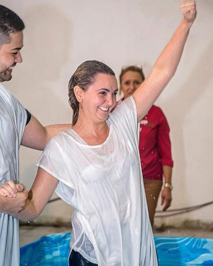 Virgínia Ferraz sorrindo, com o braço erguido